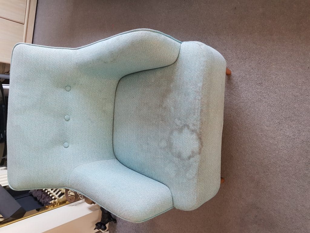 A blue chair is sitting on a carpet in a room.