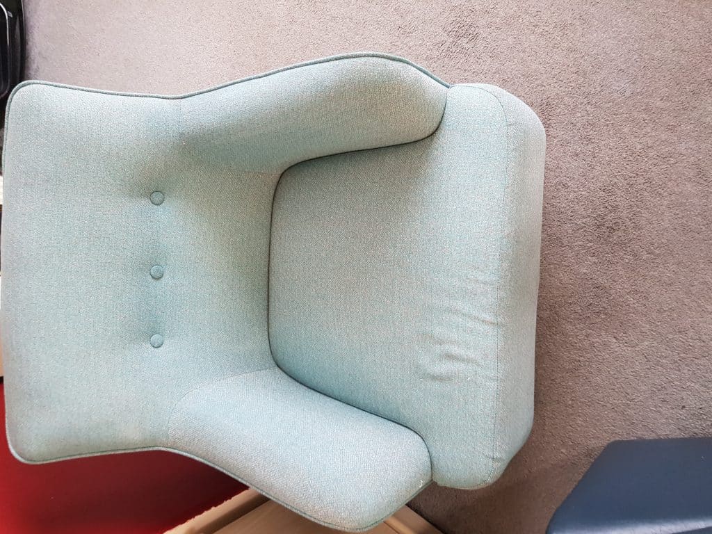 A blue chair is sitting on the floor in a room.
