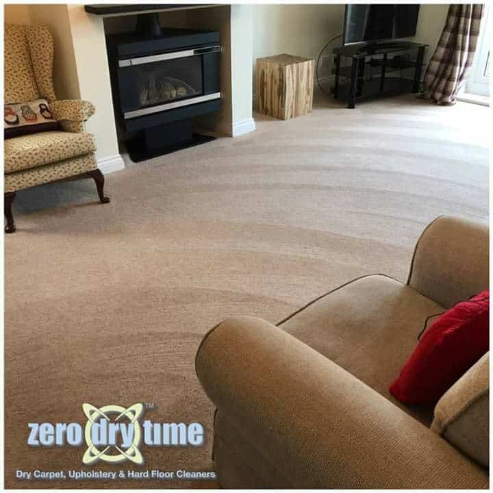 A living room with beige carpets and a fireplace.