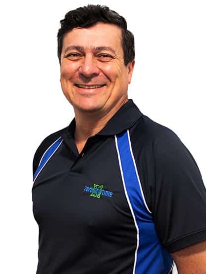 A smiling man wearing a black and blue polo shirt.