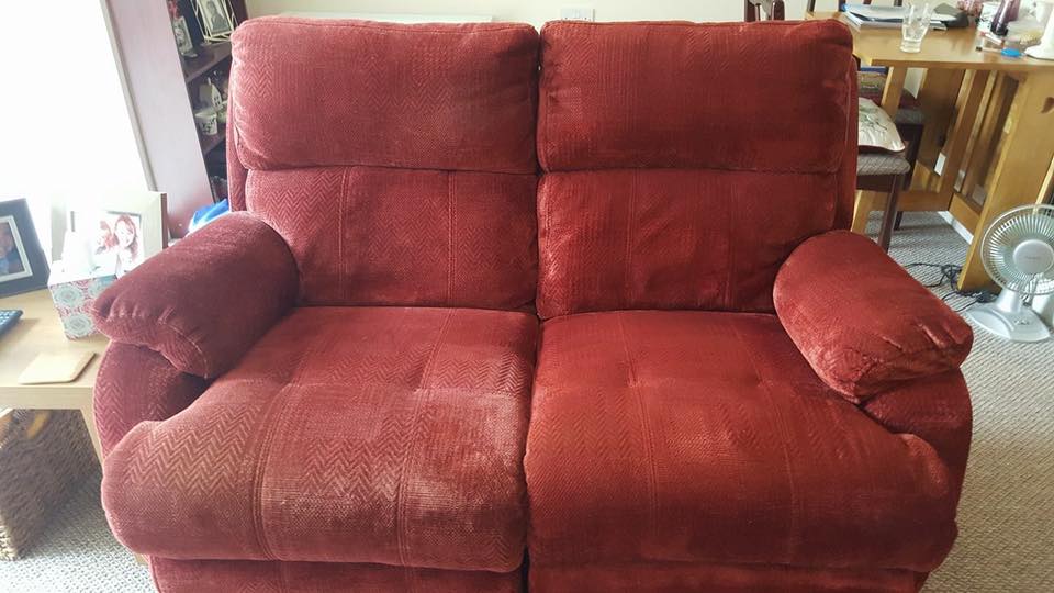 A red recliner chair in a living room.