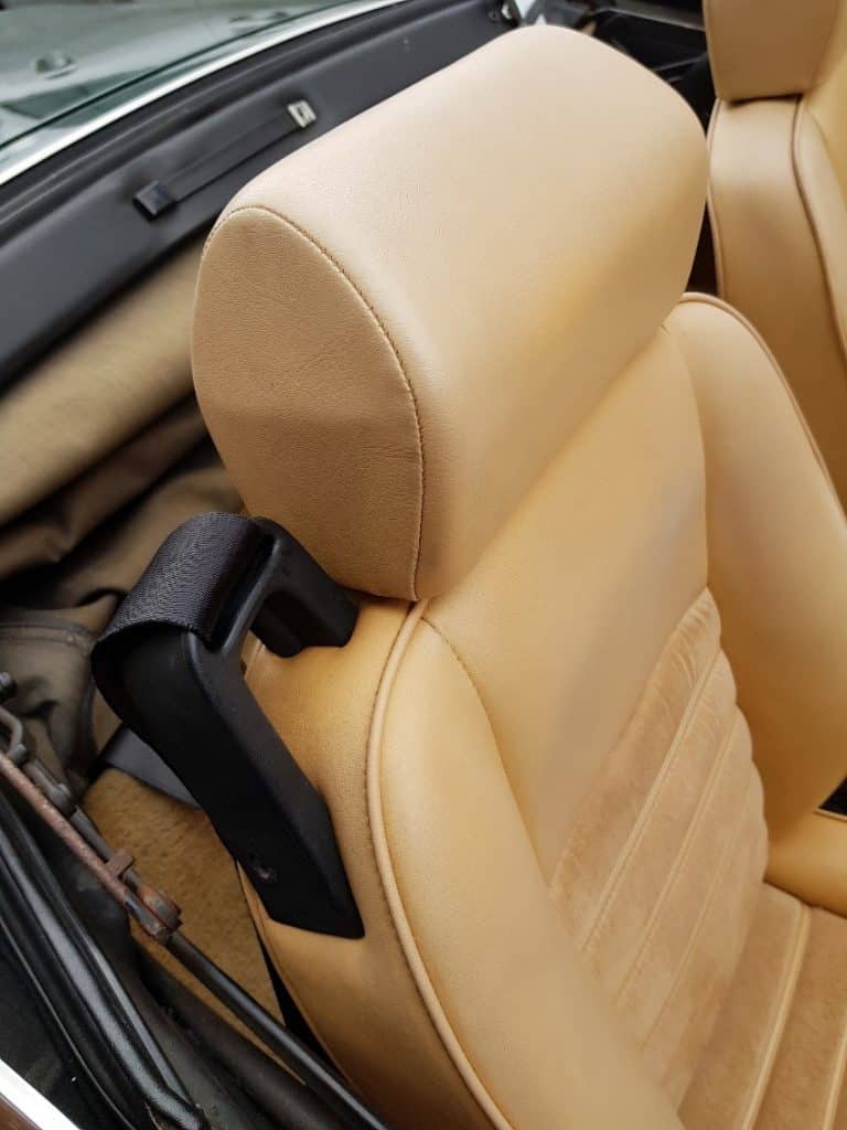 The interior of a tan sports car with leather seats.