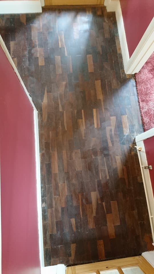 A wooden floor in a room with red walls.