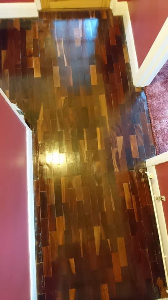 A wooden floor in a house with red walls.