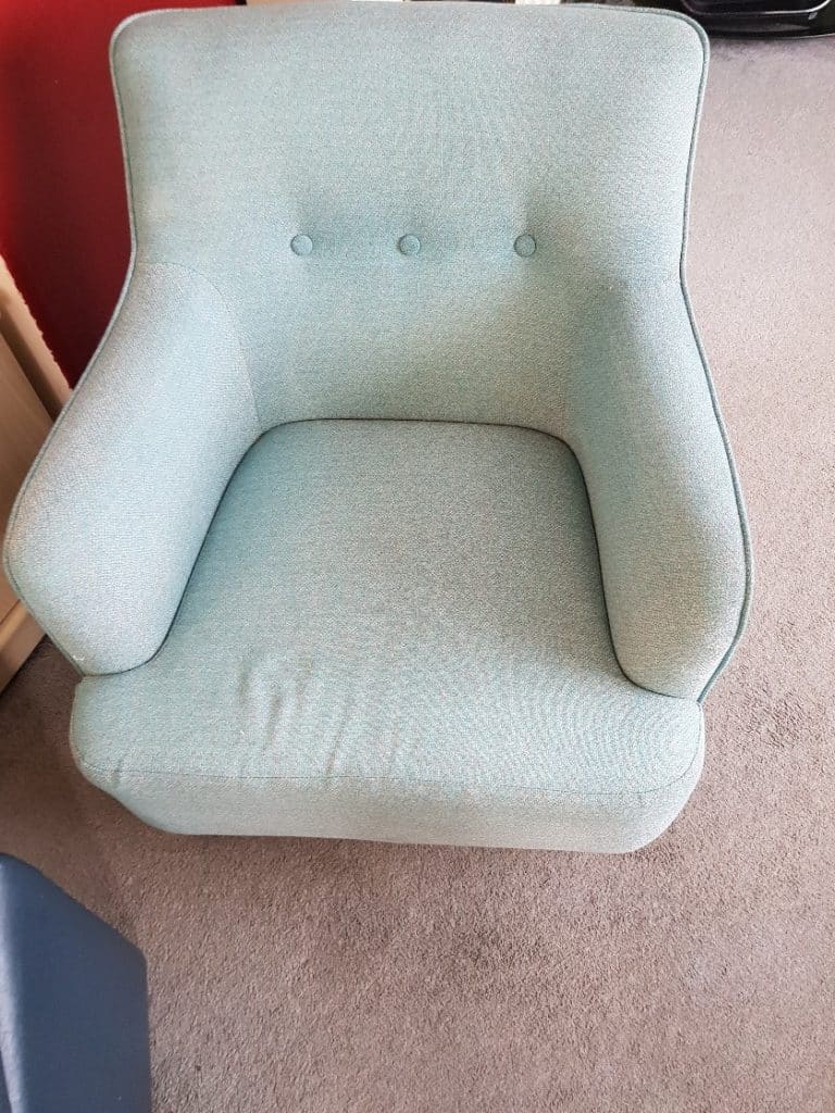 A light blue chair in a room.